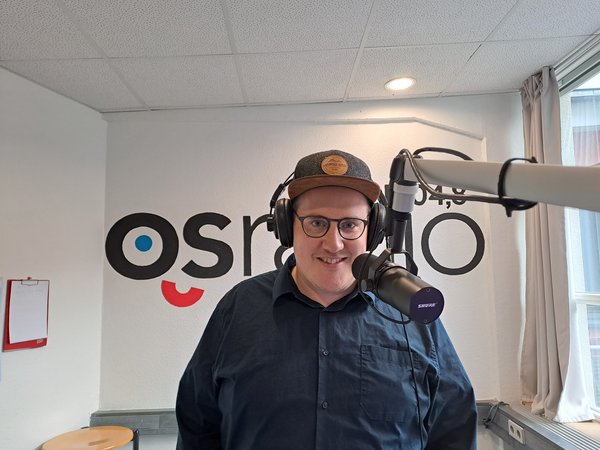 Tom Herter steht im Studio von OSRadio und nimmt den Podcast "Schinkel-Stimmen" auf. 