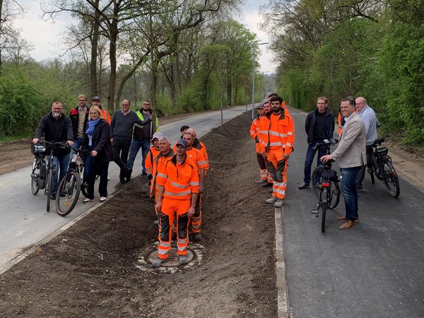 Gruppenfoto mit dem Verlauf des neuen Radweges im Hintergrund