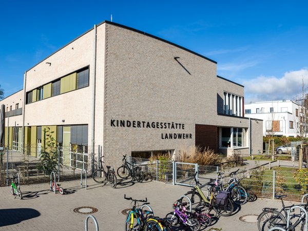Ein großes modernes Gebäude, im Vordergrund eine Fläche mit Fahrrädern.